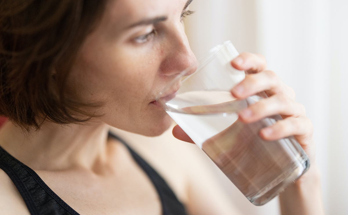 A person drinking water and taking supplements to combat motion sickness