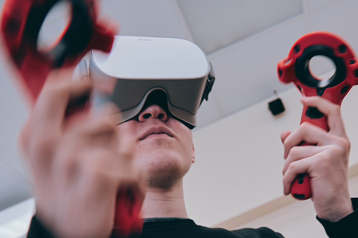 A person wearing a VR headset and exploring an immersive environment with a controller in their hand