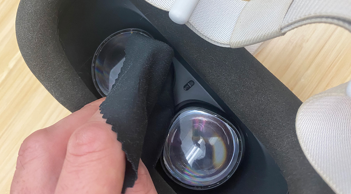 A person cleaning their VR lenses with a microfiber cloth