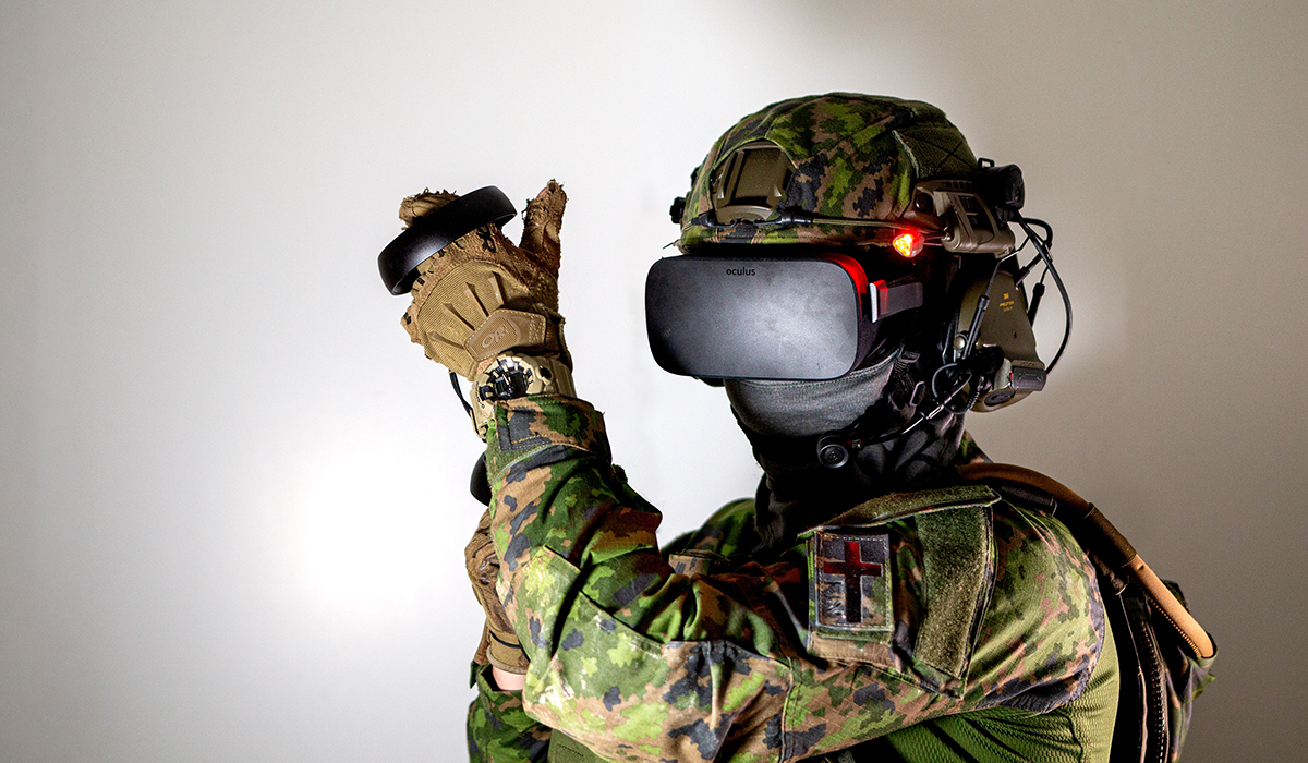 A soldier wearing a virtual reality headset and using a controller to interact with a simulated environment
