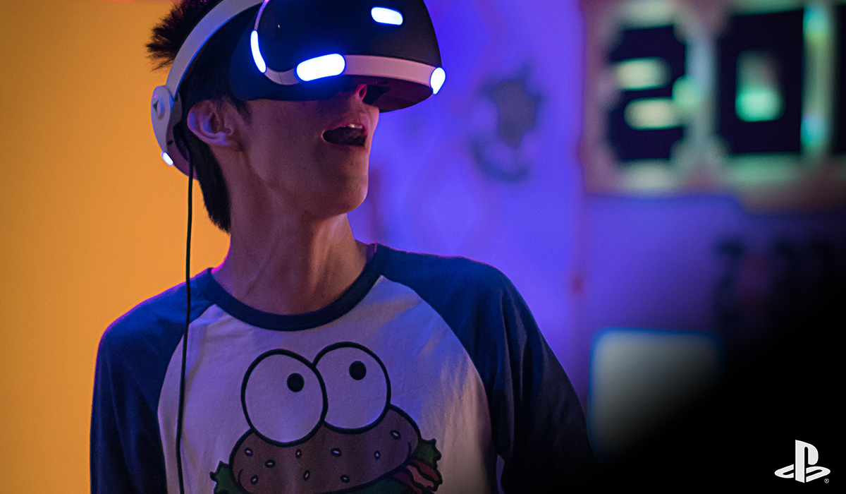 A person wearing a PlayStation VR headset, playing a VR game