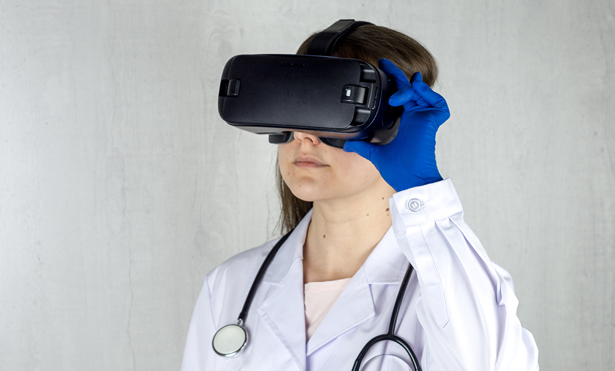 A person wearing a virtual reality headset, training with a medical simulation