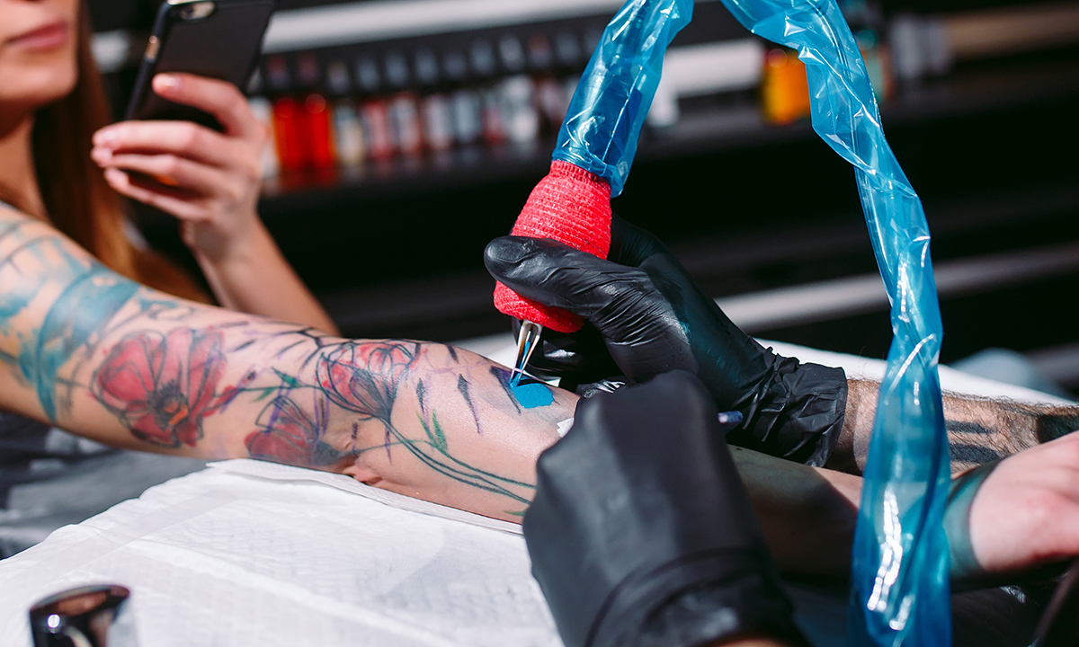 A person getting an augmented reality tattoo on their arm